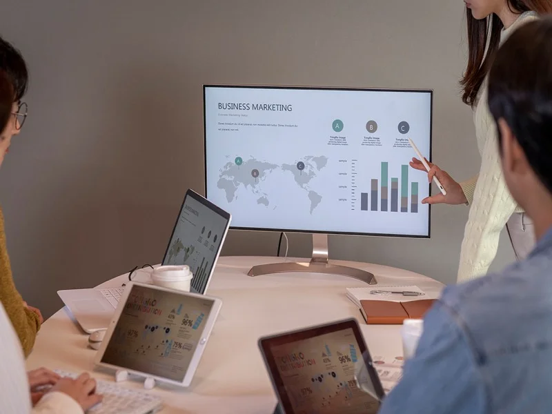 기획 회의 — 모니터와 태블릿으로 데이터를 분석하며 프로젝트를 기획하는 팀